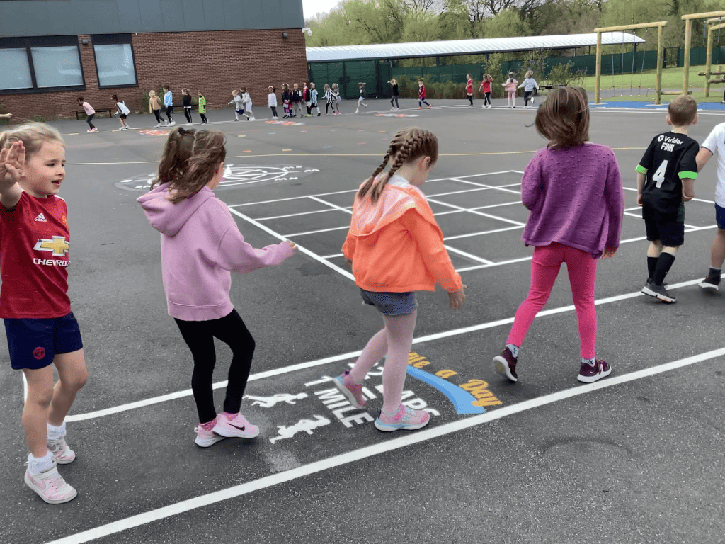 Year 1 pupils walk in a line using the new playground markings