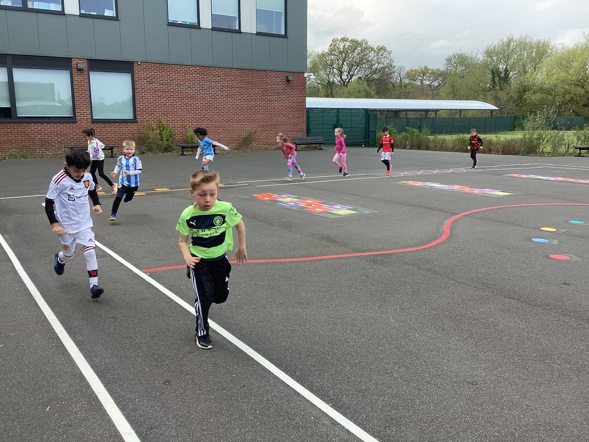 Year 2 pupils from Cheadle Hulme Primary School run along the playground track as they complete their section of the walk for the Together Trust