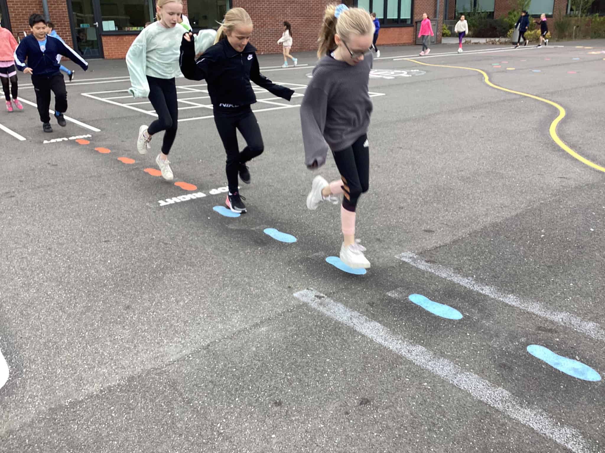 Pupils in Year 4 hop across the new playground markings during their section of the walk