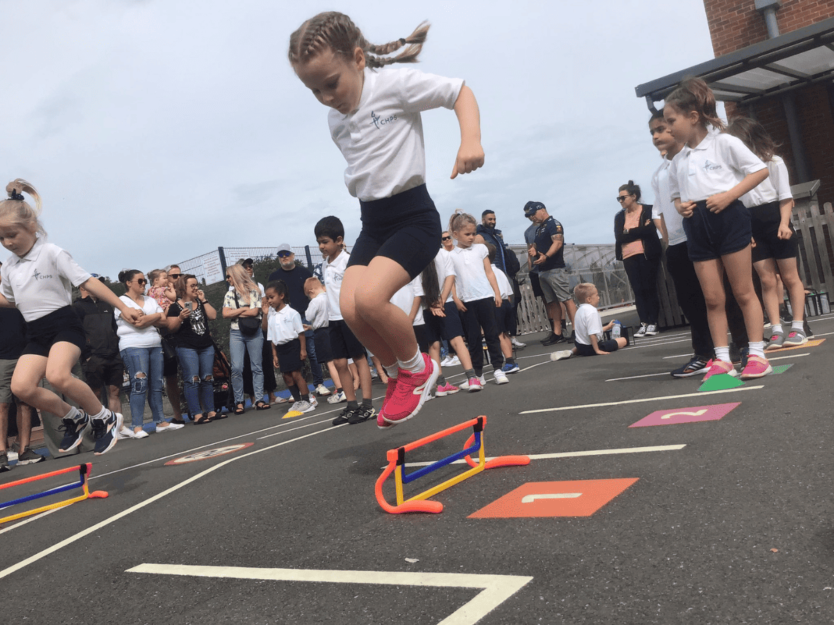 A pupil jumps over an obstacle at Cheadle Hulme Primary School Sports Day 2023